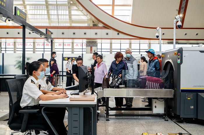 关员在磨憨铁路口岸出境旅检大厅通过CT机对旅客行李物品进行监管+赵能+摄