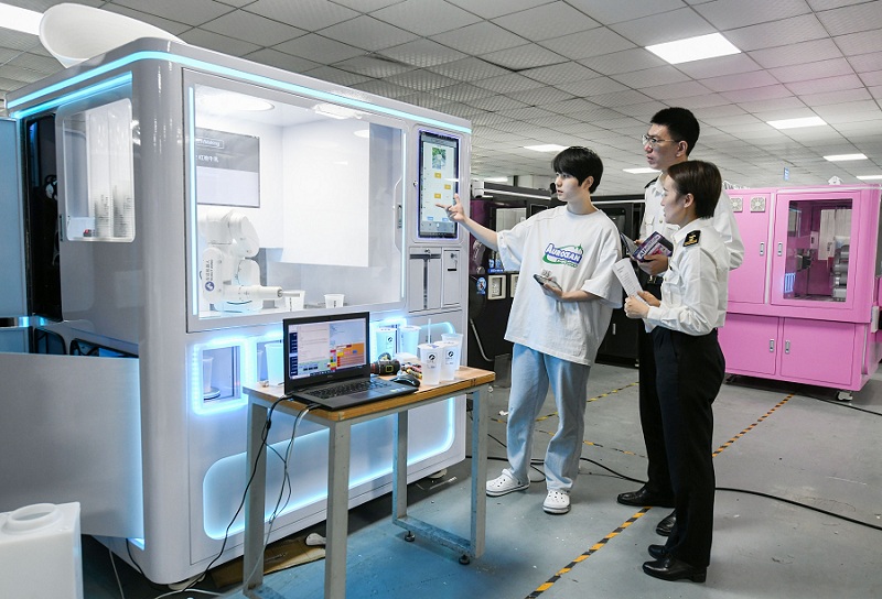 图为：关员前往AI咖啡机器人出口企业开展现场调研