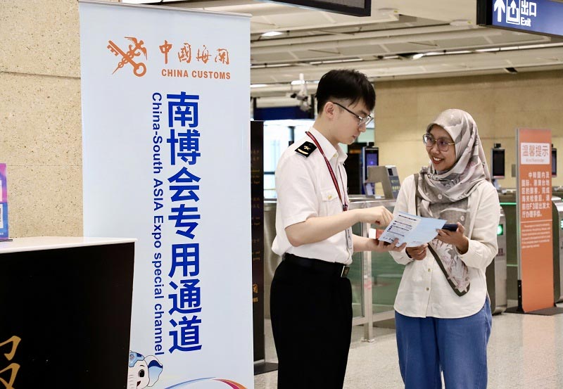 关员在昆明机场口岸为入境旅客介绍第10届南博会相关政策 关员在昆明机场口岸为入境旅客介绍第10届南博会相关政策
