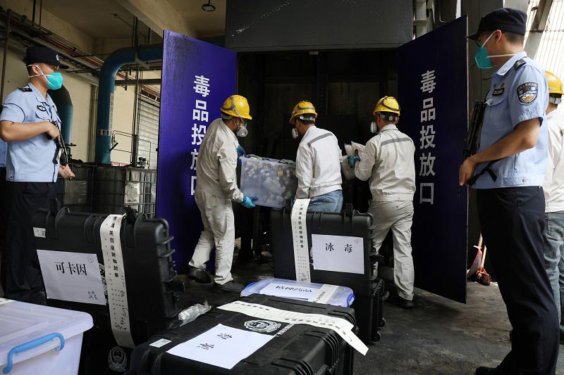 在2026年广州海关毒品销毁现场，工作人员将待销毁的毒品搬入销毁区