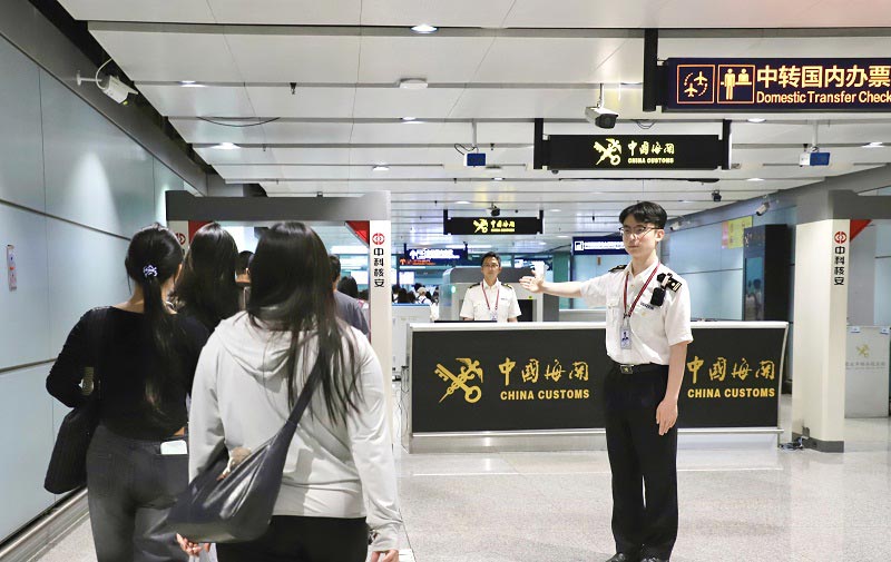关员在昆明机场口岸“国际转国内”通程通道引导旅客通关 关员在昆明机场口岸“国际转国内”通程通道引导旅客通关