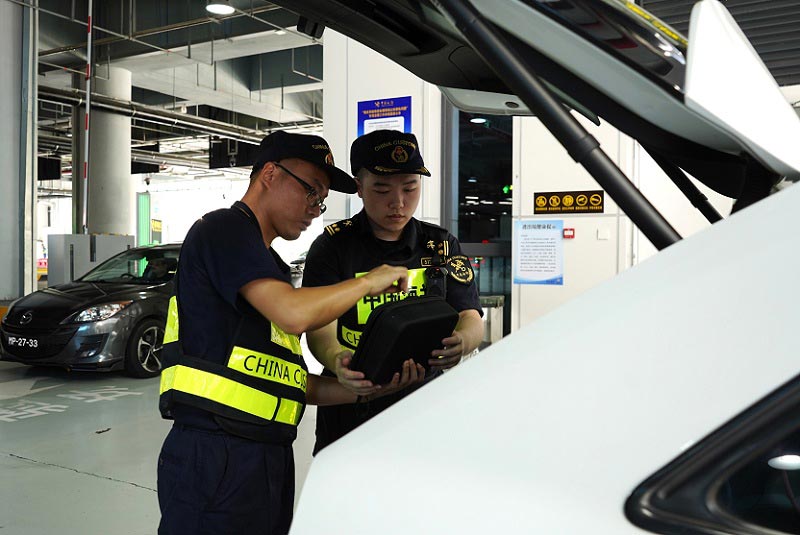 拱北海关关员对跨境小客车开展现场监管 拱北海关关员对跨境小客车开展现场监管
